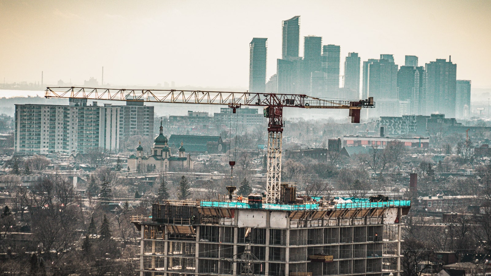 Image of Toronto's skyline with a large crane and construction to a skyscraper in the centre
